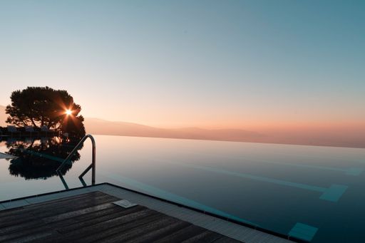 A scenic view of a swimming pool under a cloudless sky at sunset