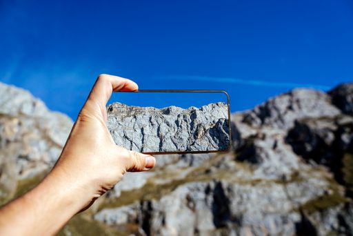 A selective focus shot of a person photographed the big stones in the mountain with a blurred background