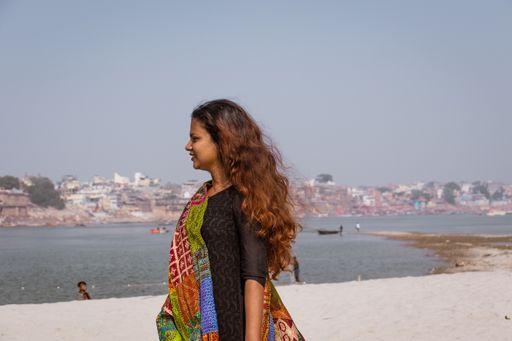 A young Indian female with a colorful scarf on a beach