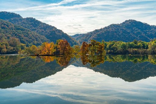 A landscape of golden fall foliage amidst a beautiful sunset backdrop in Kanawha Falls, West Virginia