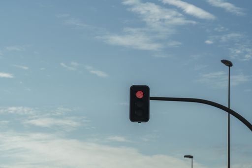 A low angle shot of a traffic light with an illuminated red light