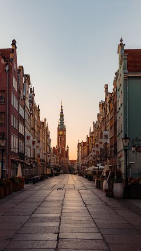 A stunning image of the historic Old Town district of Gdansk, Poland illuminated by the warm orange hues of the early morning sunrise