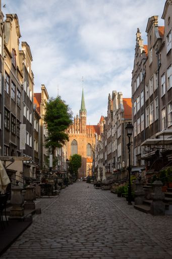 A stunning image of the historic Old Town district of Gdansk, Poland illuminated by the warm orange hues of the early morning sunrise