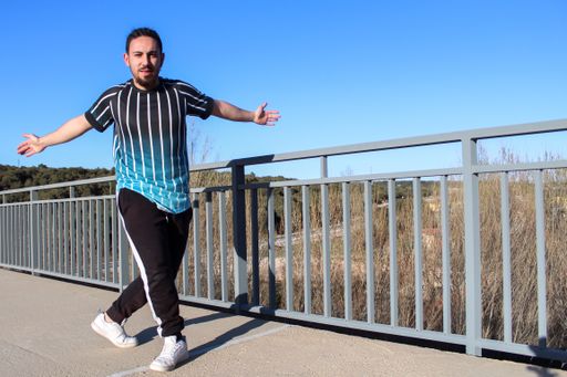 A young and positive male dancing an urban dance in the bridge on a sunny day