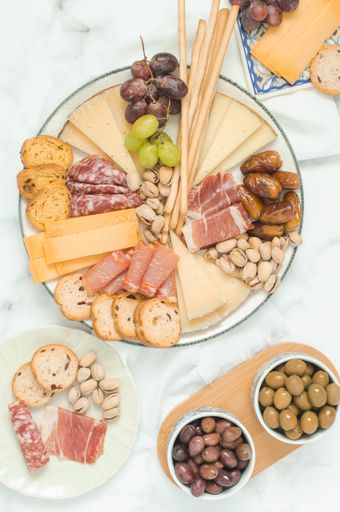 Cheese board brunch for a party with pistachios, olives, grapes and dates