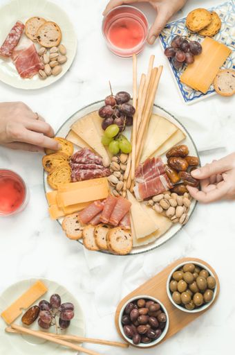 Cheese board brunch for a party with pistachios, olives, grapes and dates