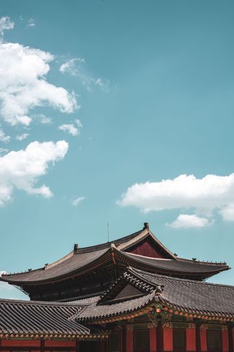A vertical shot of a traditional Korean building under the sunlight and a blue sky