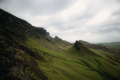 A picturesque view of Quiraing in the Isle of Skye, Scotland, with a grassy mountain