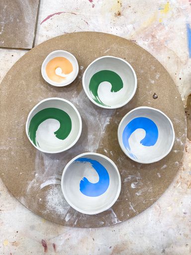 A selection of greenware ceramics bowls decorated with underglaze and ready for the first bisque fire
