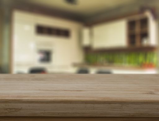A closeup of a wooden table with copyspace in the kitchen under the lights