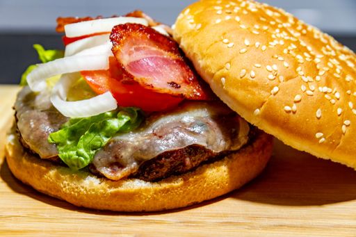 A closeup shot of a delicious burger with on a wooden board
