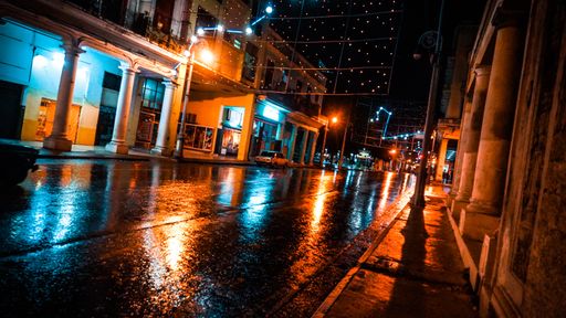 An illuminated street after rain during the rainy season at night