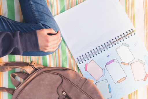 A student with a backpack studying during the picnic in the park