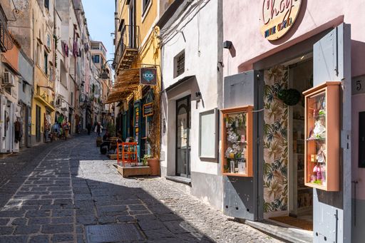 Colorful pedestrian street lined with typical shops in Procida. Procida, Campania, Italy, March. 2023