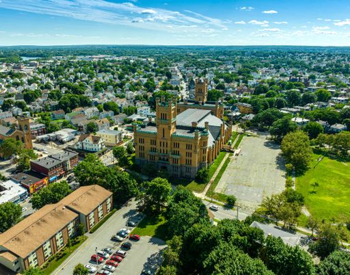 Aerial shot of the historic Cranston Street Armory in Providence, Rhode Island against a picturesque blue sky background