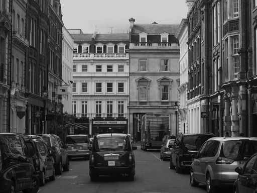 A closeup shot of a taxi driving on the street in black and white