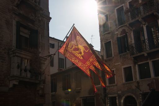 Venetian flag flying with venice in the background