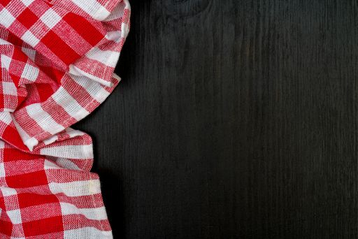 A top view of a red chequered towel on a wooden surface with space for text