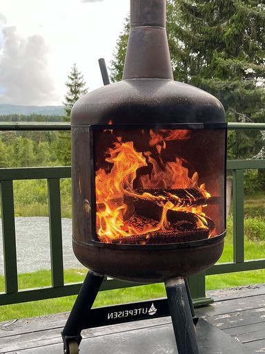 An outdoor firepit with a black steel finish