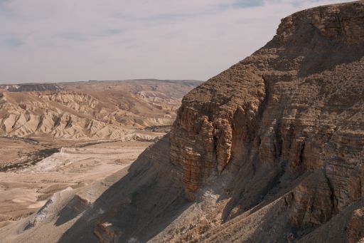 A beautiful scenery of brown badlands under a cloudy sky during daytime