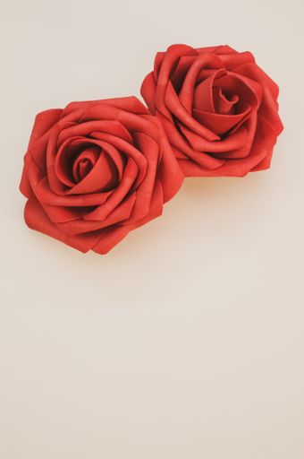 A vertical shot of artificial red roses isolated on light background