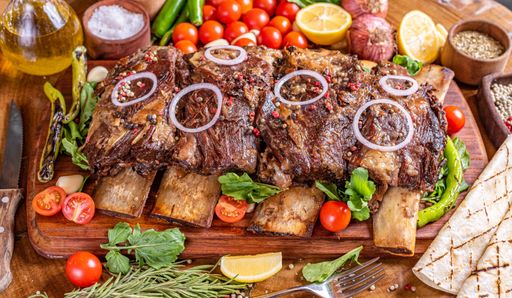 A closeup of a tasty beef rib steak on the wooden cut board under the natural light