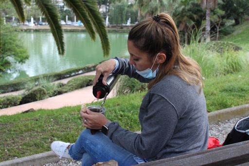 A closeup shot of a Caucasian female pouring tea in the park