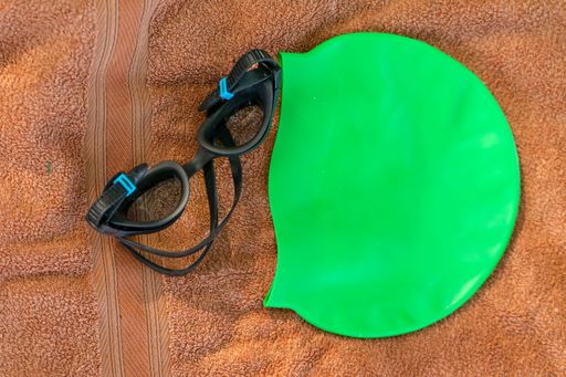 A closeup of swimming gear on a brown towel under the natural light