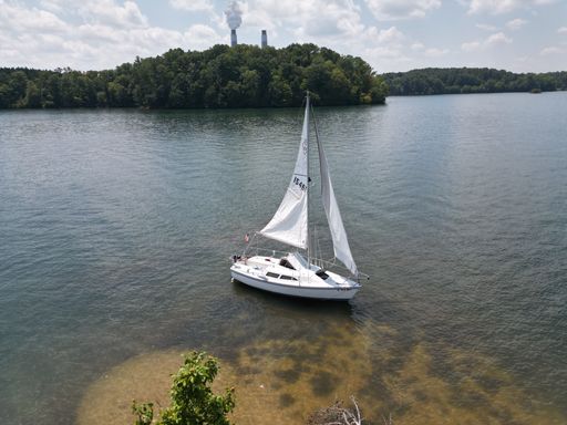 An aerial view of a sailboat on a lake in summer