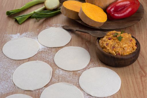 The ingredients for making Argentinian empanadas stuffed with vegetables and squash on wooden surface