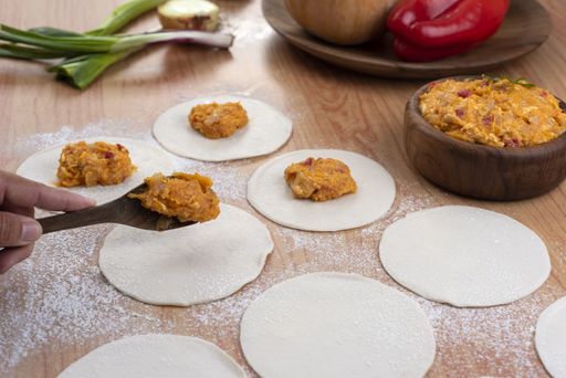 The ingredients for making Argentinian empanadas stuffed with vegetables and squash on wooden surface