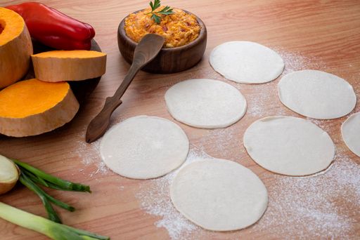 The ingredients for making Argentinian empanadas stuffed with vegetables and squash on wooden surface
