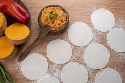 The ingredients for making Argentinian empanadas stuffed with vegetables and squash on wooden surface
