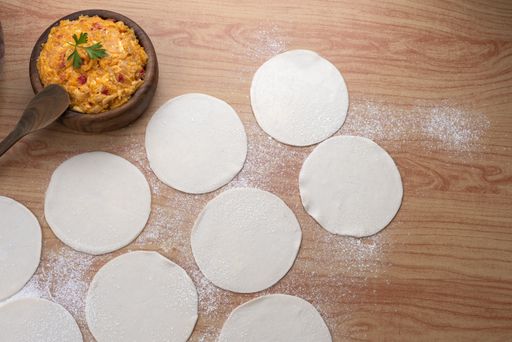 The ingredients for making Argentinian empanadas stuffed with vegetables and squash on wooden surface