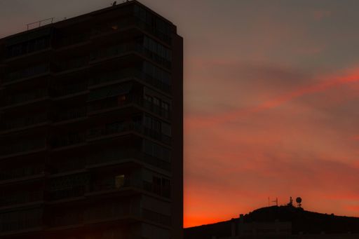 A beautiful shot of fiery red sunset seen through residential building silhouettes