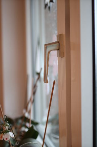 A closeup of a window knob under the lights with a blurry background