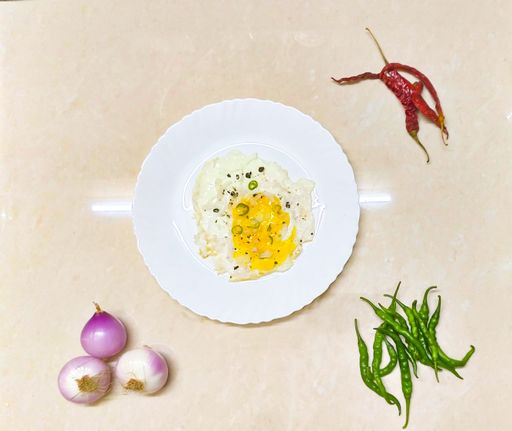 A top view of tasty scrambled eggs with spices and green peppers in a frying pan