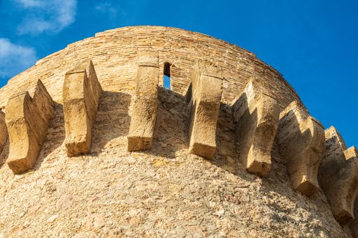 A low angle shot of the Torre de Piles on the Piles Beach under a blue sky and sunlight in Spain