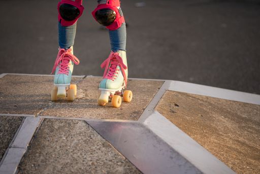 A vertical shot of a rollerskater wearing roller skates with pink laces