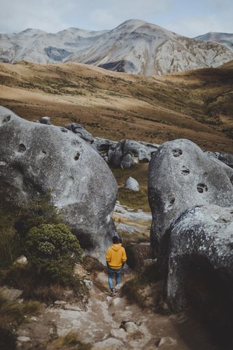A vertical high angle shot of a male walking in the Castle Hill in New Zealand