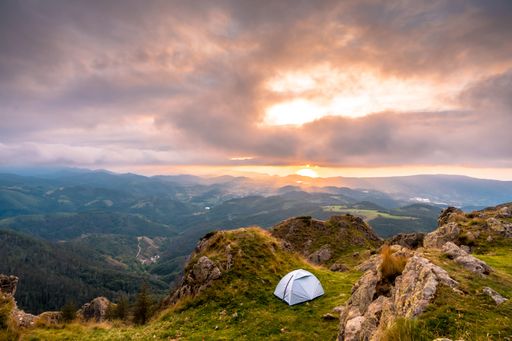 A closeup shot of wild camping on the top of a mountain at sunset