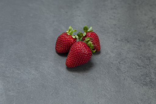 A closeup shot of red juicy strawberries on a plain background