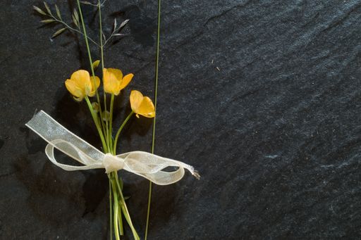 A small bouquet of wild yellow buttercup on a black background
