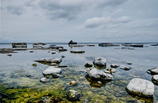 The mossy rock formations in the lake under the cloudy sky