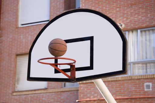 A view at the basketball ball about to enter the basket on the street court
