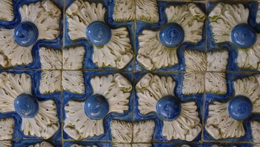 A closeup shot of a floral pattern carving on a blue wall