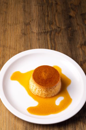 A vertical shot of a creme caramel cake baked with flan served on a white plate