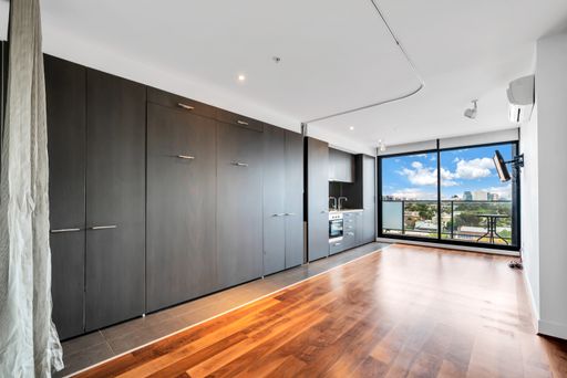 An unfurnished living room with laminate flooring and glass window