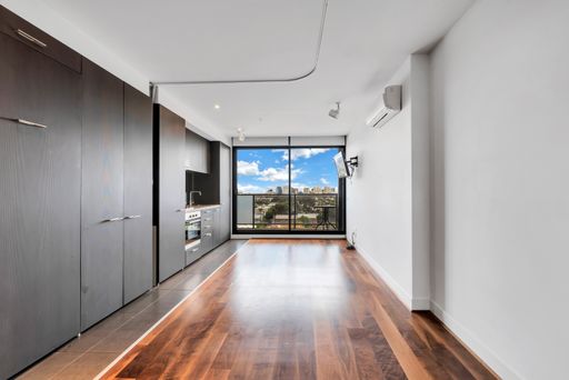 An unfurnished living room with laminate flooring and glass window