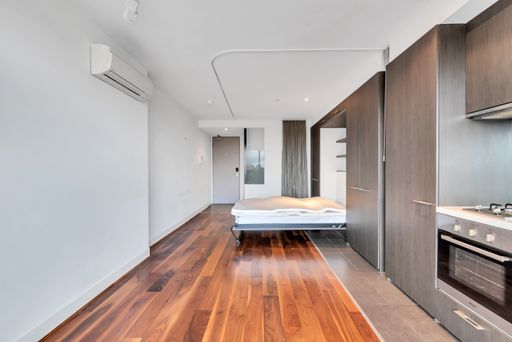 A bedroom with laminate flooring and kitchen